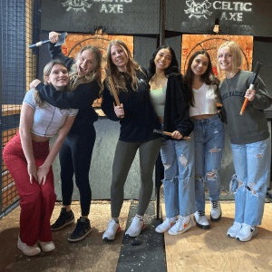 Friends holding axes in front of Celtic Axe targets