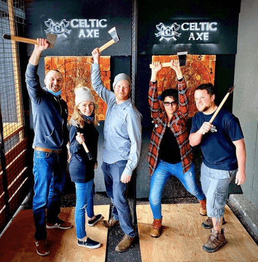 Group of friends with axes raised at Celtic Axe